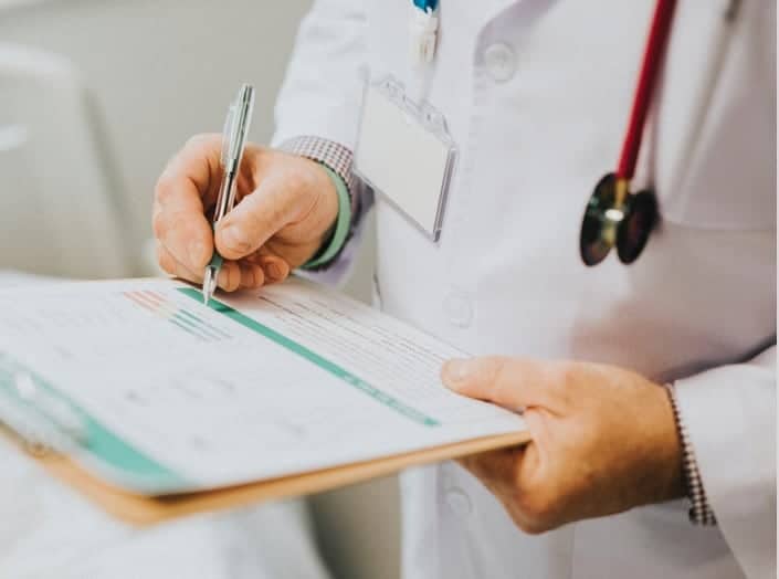 A doctor taking notes on a clipboard