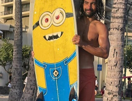 Juan Juan Holding a Surfboard with a Minion Image