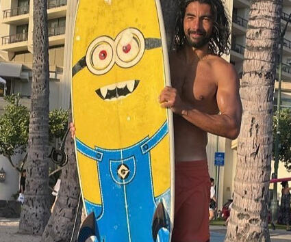 Juan Juan Holding a Surfboard with a Minion Image
