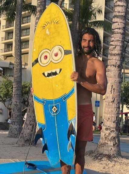 Juan Juan Holding a Surfboard with a Minion Image